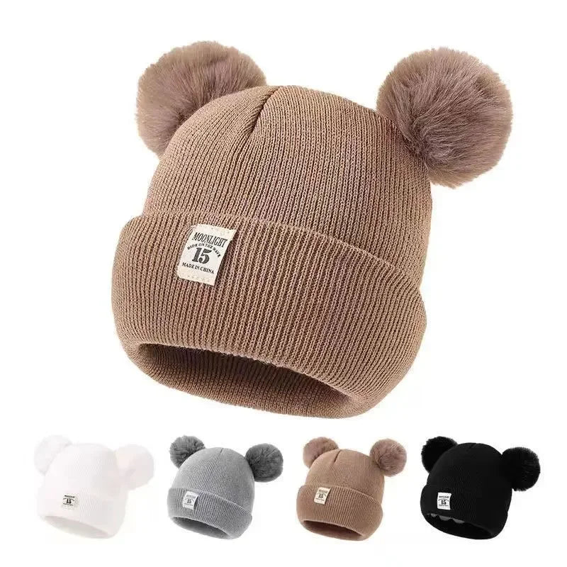 Gorro de lã em cor sólida, ideal para recém-nascidos. Com pompom, é perfeito para o inverno, mantendo os pequenos aquecidos. Disponível para crianças de 0 a 3 anos.