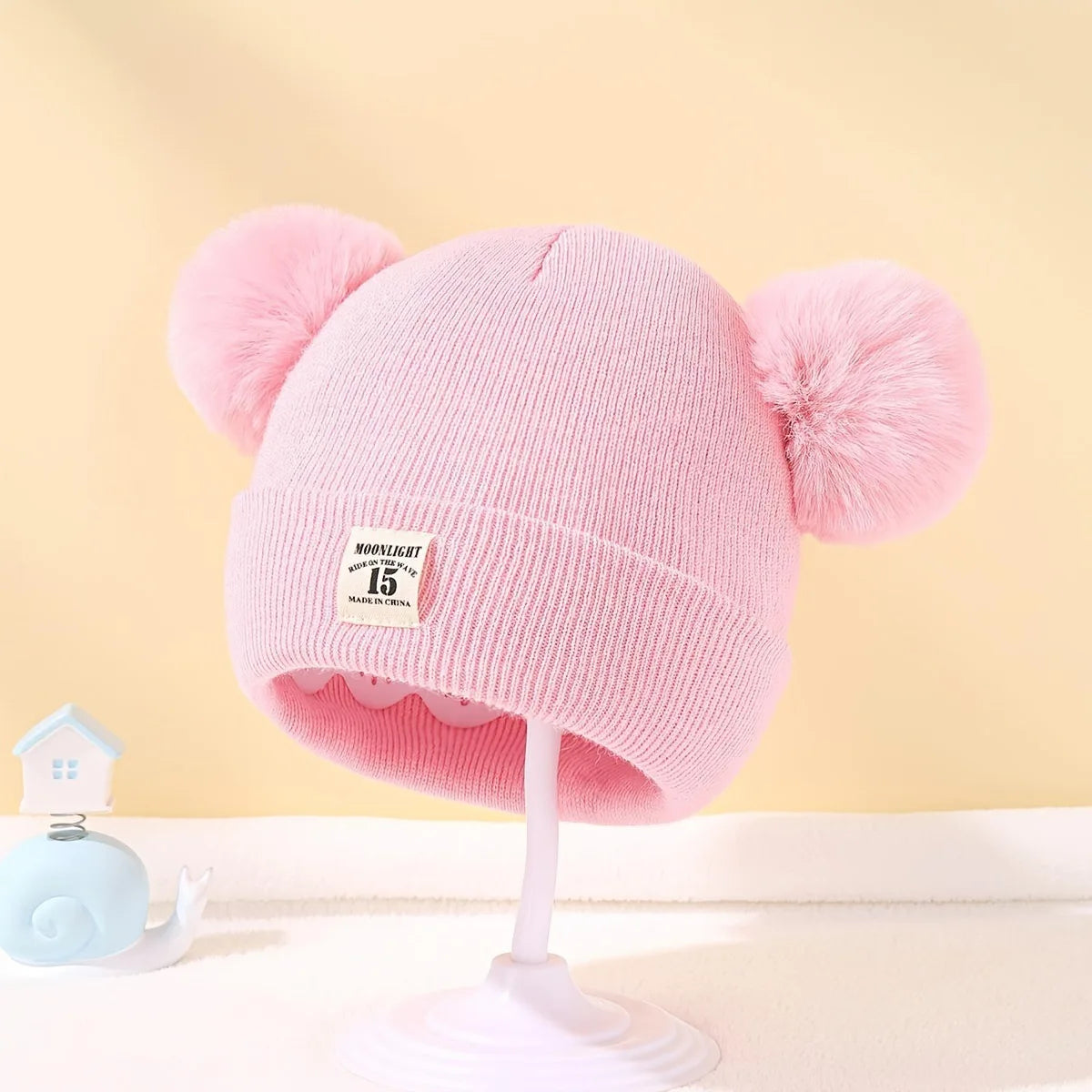 Gorro de lã em cor sólida, ideal para recém-nascidos. Com pompom, é perfeito para o inverno, mantendo os pequenos aquecidos. Disponível para crianças de 0 a 3 anos.