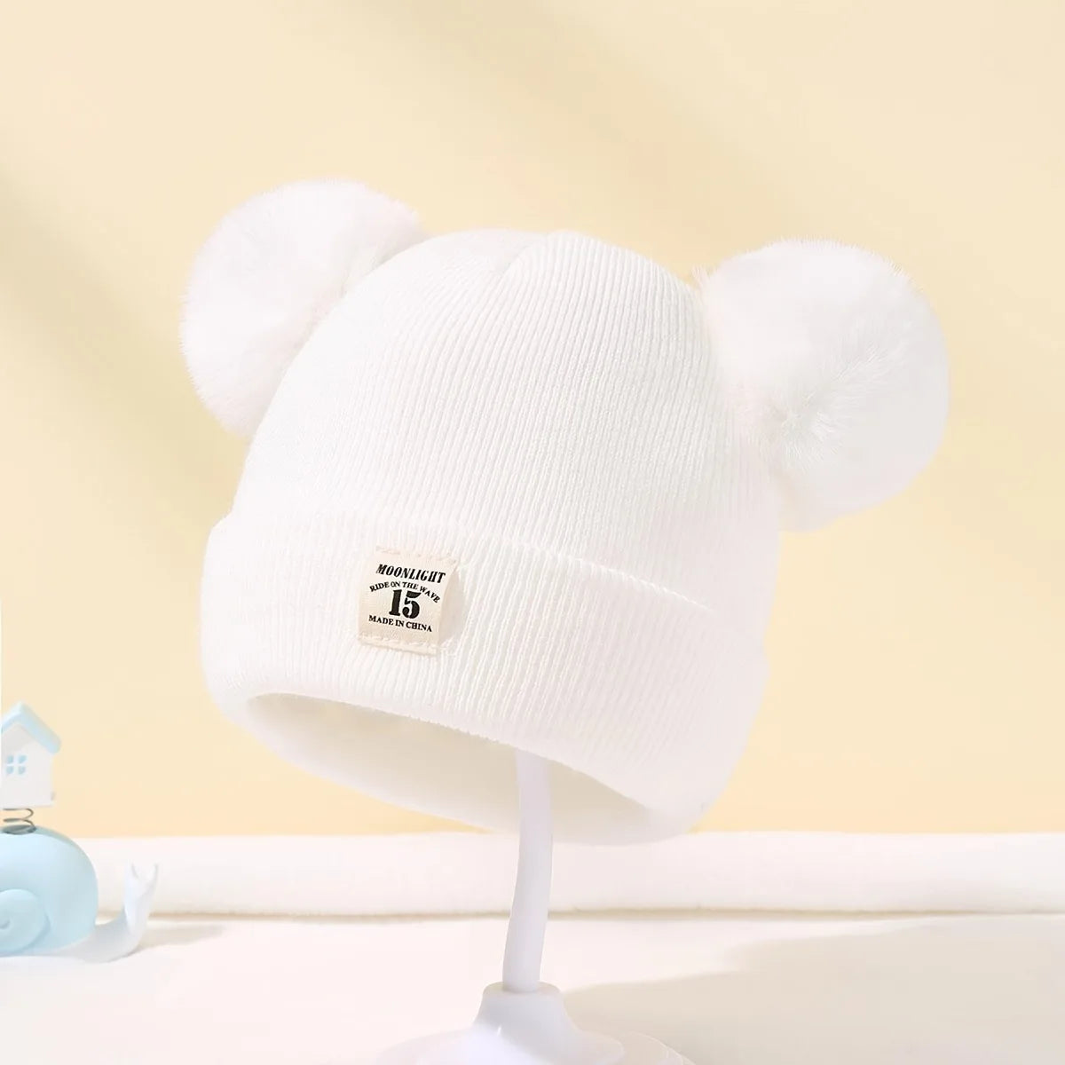 Gorro de lã em cor sólida, ideal para recém-nascidos. Com pompom, é perfeito para o inverno, mantendo os pequenos aquecidos. Disponível para crianças de 0 a 3 anos.
