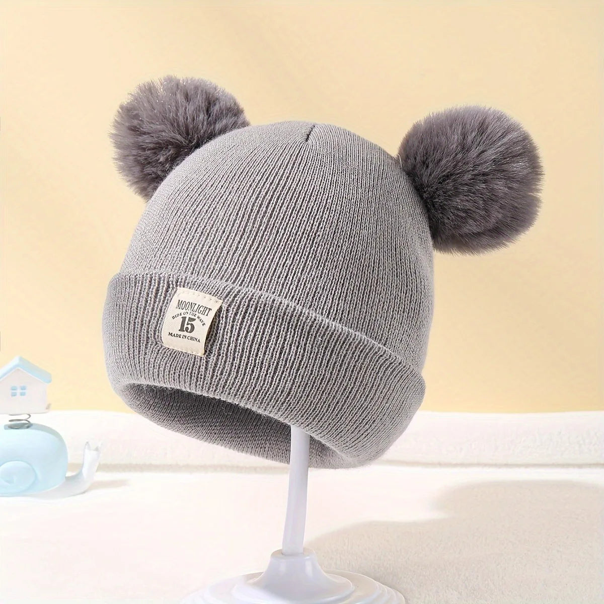 Gorro de lã em cor sólida, ideal para recém-nascidos. Com pompom, é perfeito para o inverno, mantendo os pequenos aquecidos. Disponível para crianças de 0 a 3 anos.