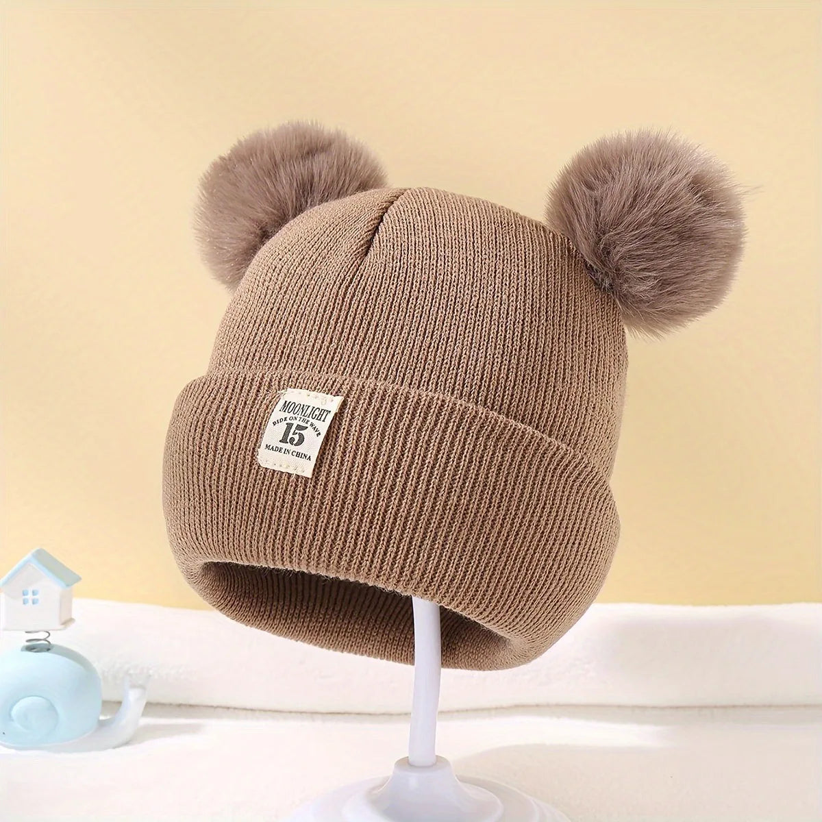 Gorro de lã em cor sólida, ideal para recém-nascidos. Com pompom, é perfeito para o inverno, mantendo os pequenos aquecidos. Disponível para crianças de 0 a 3 anos.