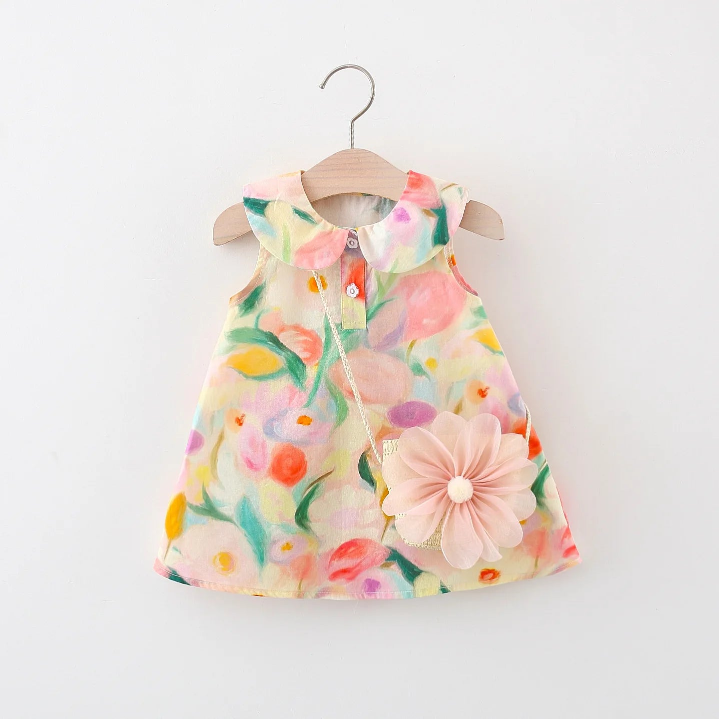 Apresentamos um lindo conjunto de verão para meninas: um vestido de algodão sem mangas com gola de boneca e uma bolsa crossbody combinando, ambas com flores grandes e doces. Perfeito para dias ensolarados!